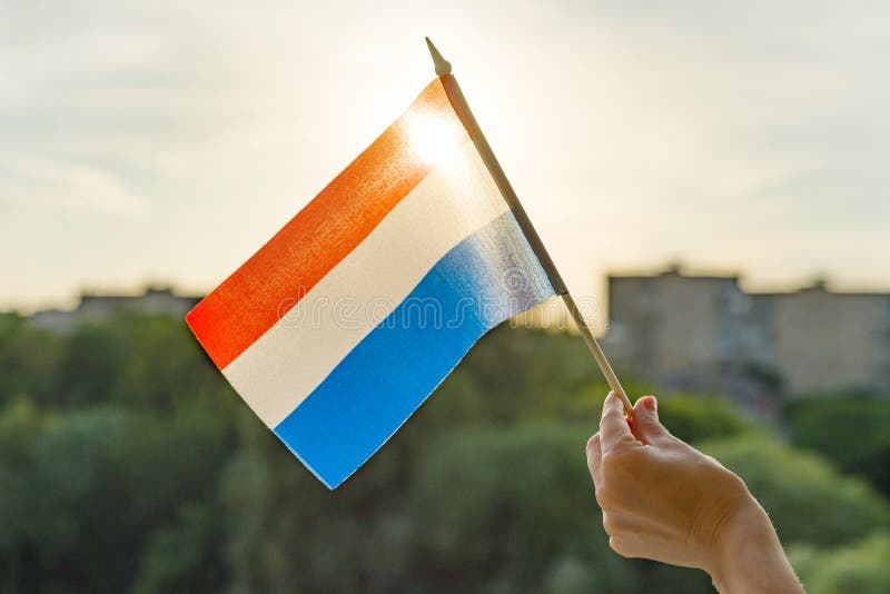 De handholding Nederland markeert een open venster Blauwe hemel als achtergrond, silhouet van de stad, zonsondergang