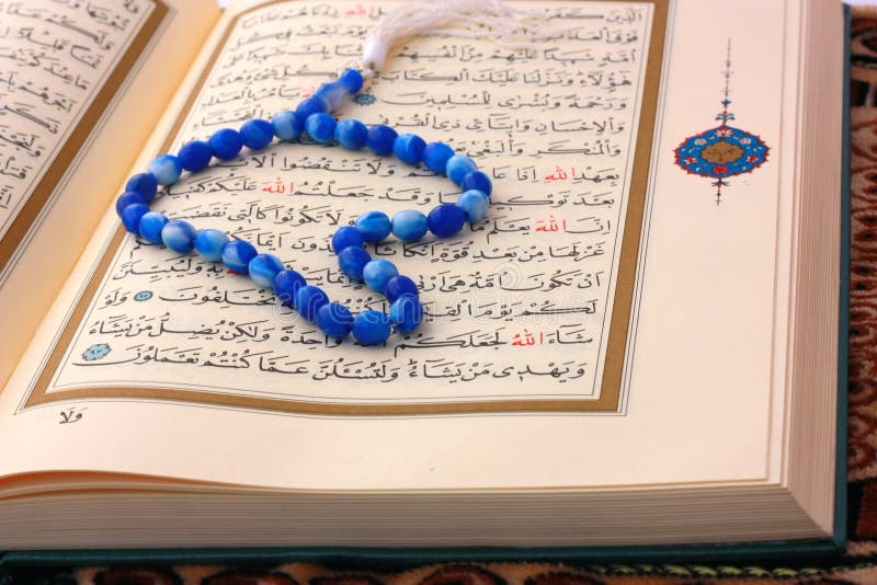 The Holy Koran page with blue rosary. Islam religion concept. The Holy Koran page with blue rosary. Islam religion concept