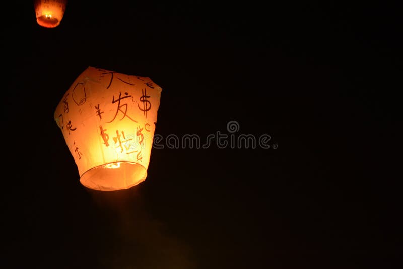 De hemellantaarn die in de nachthemel bij het festival in Pingxi drijven, de Chinese tekst is een wens voor geld in het Nieuwjaar stock afbeelding De hemellantaarn die in de nachthemel bij het festival in Pingxi drijven, de Chinese tekst is een wens voor geld in het Nieuwjaar stock afbeelding