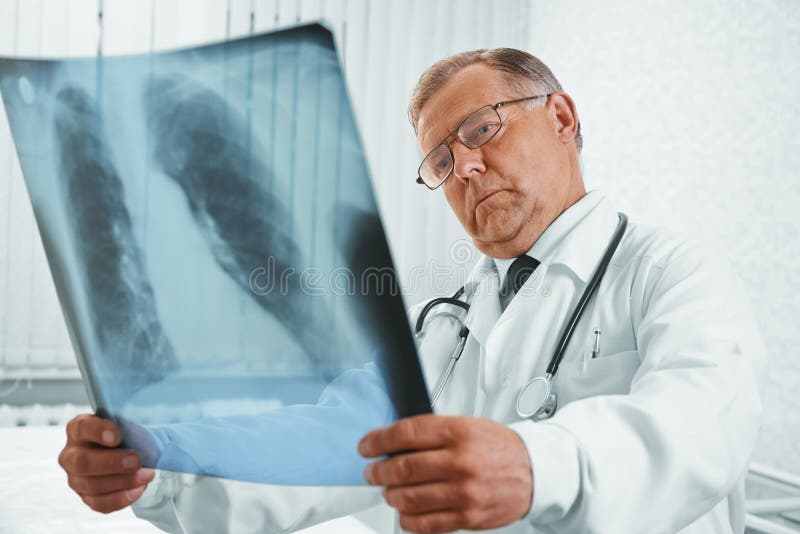 De hogere arts onderzoekt x-ray beeld royalty-vrije stock afbeelding De hogere arts onderzoekt x-ray beeld royalty-vrije stock afbeelding