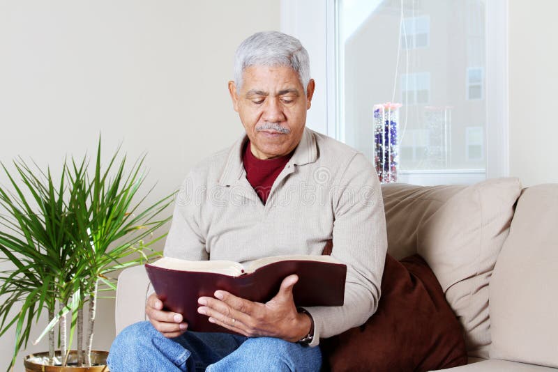 Man reading the bible in his home. Man reading the bible in his home