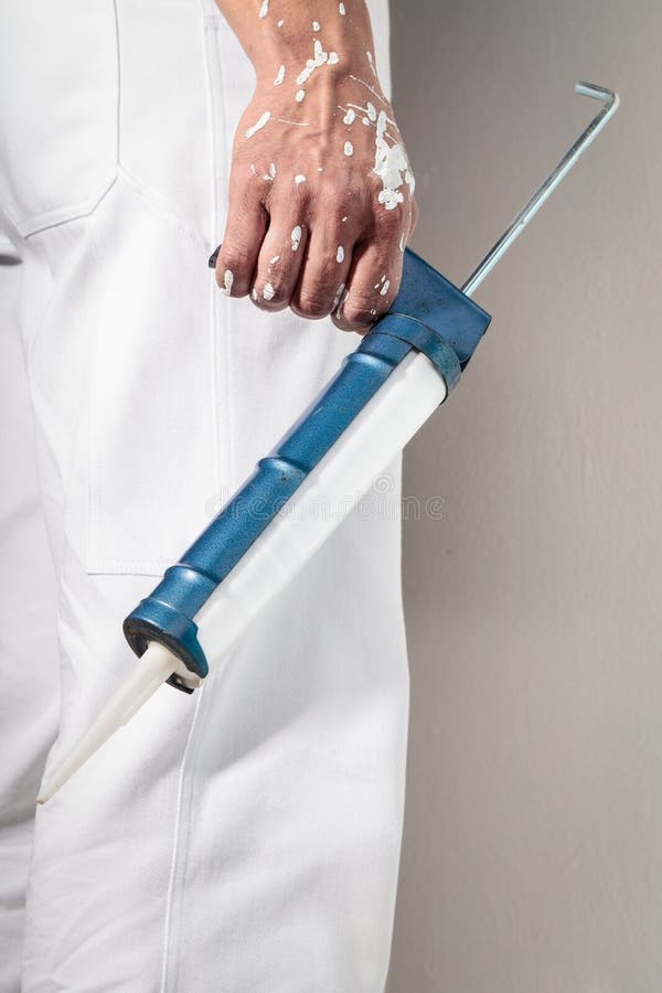 De holdings Waterdicht makend Kanon van de werkmanshand voor Siliconedichtingsproduct stock afbeelding De holdings Waterdicht makend Kanon van de werkmanshand voor Siliconedichtingsproduct stock afbeelding