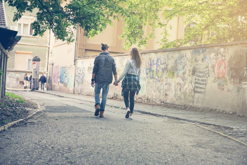 De holdingshanden van het paar in openlucht Lopende straat stock afbeeldingen De holdingshanden van het paar in openlucht Lopende straat stock afbeeldingen