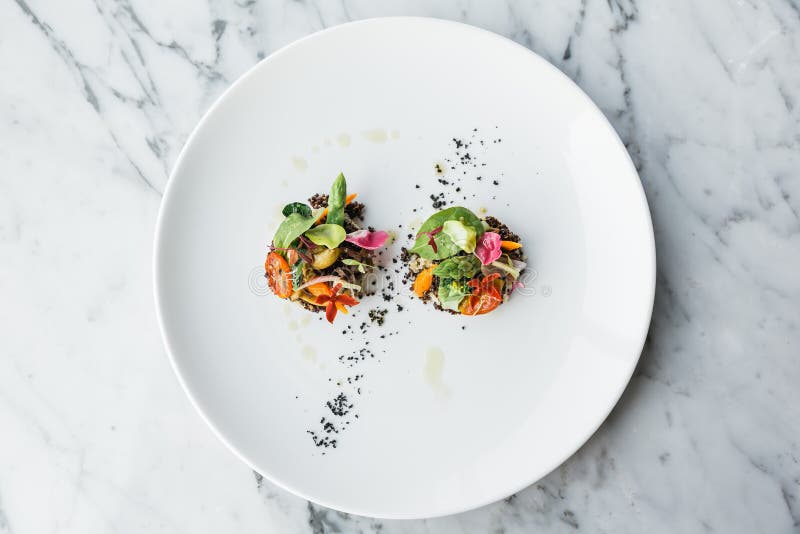 De hoogste die mening van Quinoa canapes bovenste laagje met pan schroeide asperge, tomaten en babygroenten en olijfolie op witte stock afbeelding De hoogste die mening van Quinoa canapes bovenste laagje met pan schroeide asperge, tomaten en babygroenten en olijfolie op witte stock afbeelding