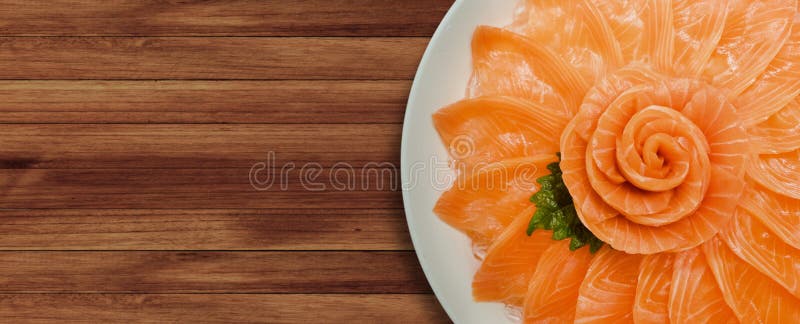 De hoogste mening van zalmsashimi dient op bloemvorm in de witte boot van de ijskom op houten lijstachtergrond, Japanse stijl royalty-vrije stock foto De hoogste mening van zalmsashimi dient op bloemvorm in de witte boot van de ijskom op houten lijstachtergrond, Japanse stijl royalty-vrije stock foto
