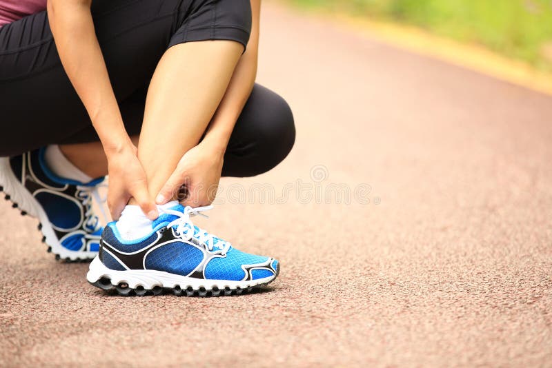Young woman runner holder her twisted ankle. Young woman runner holder her twisted ankle