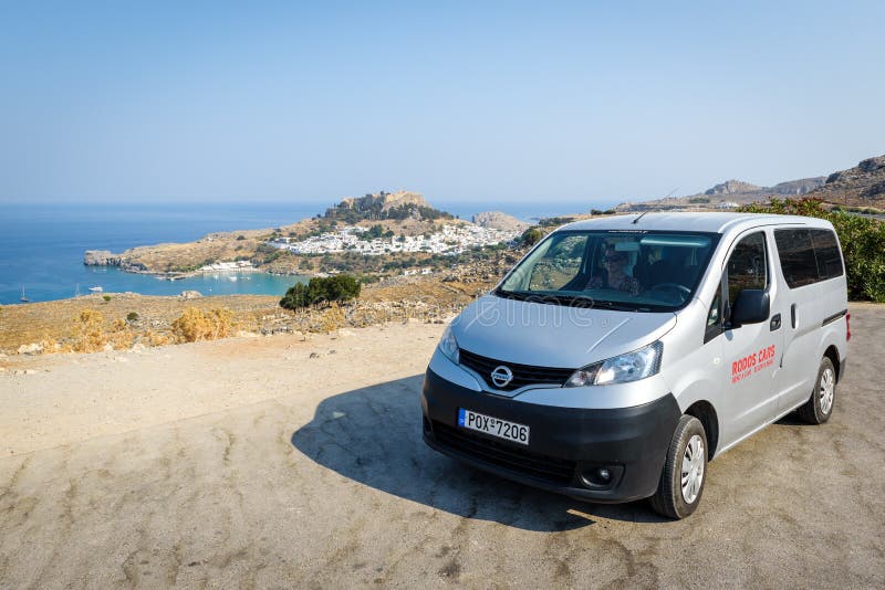 De huur Nissan Evalia blijft dichtbij Lindos-stad op de stad van Rhodos, Griekenland wordt geparkeerd dat royalty-vrije stock afbeeldingen De huur Nissan Evalia blijft dichtbij Lindos-stad op de stad van Rhodos, Griekenland wordt geparkeerd dat royalty-vrije stock afbeeldingen