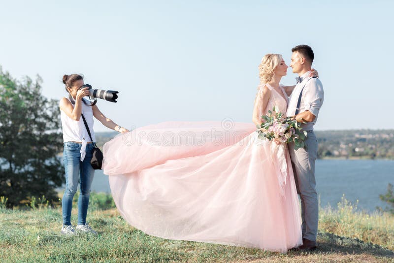 De huwelijksfotograaf neemt beelden van bruid en bruidegom royalty-vrije stock afbeelding De huwelijksfotograaf neemt beelden van bruid en bruidegom royalty-vrije stock afbeelding