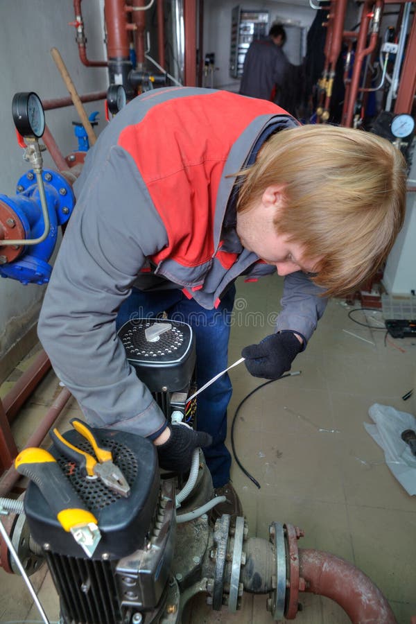 De industriële Diensten van de Pompreparatie, de technicus verbindt een moto stock foto De industriële Diensten van de Pompreparatie, de technicus verbindt een moto stock foto