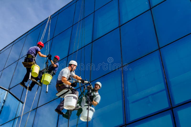 De industriële klimmers passen silicone op verbindingen tussen wind toe stock afbeelding De industriële klimmers passen silicone op verbindingen tussen wind toe stock afbeelding