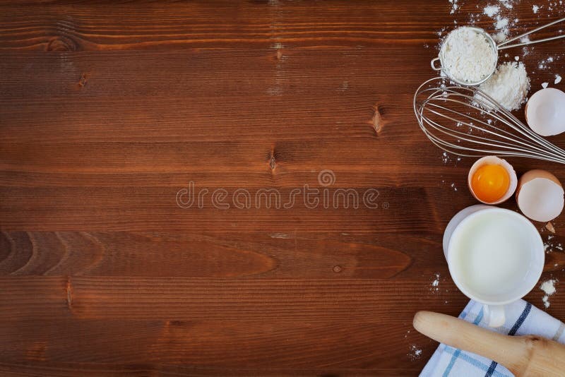 De ingrediënten voor bakseldeeg met inbegrip van bloem, eieren, melk, zwaaien en deegrol op houten rustieke achtergrond