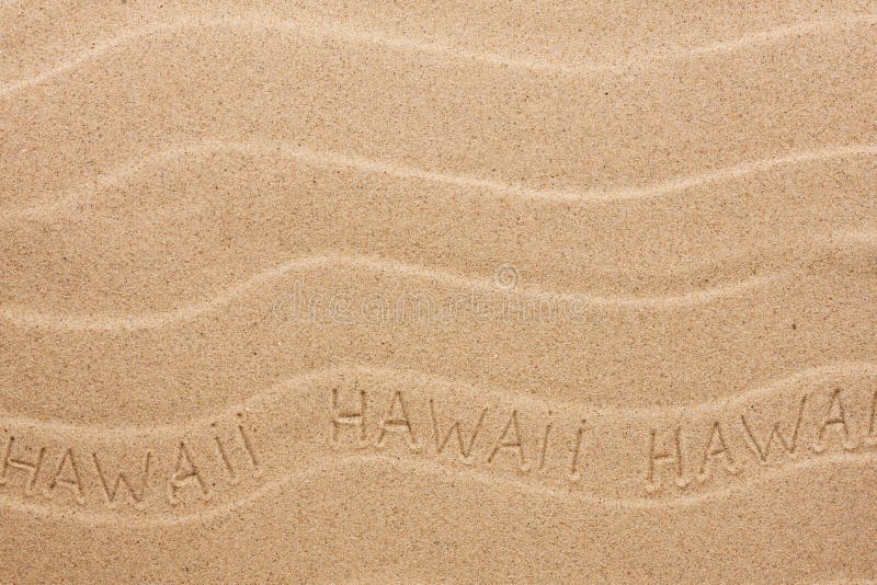 De inschrijving van Hawaï op het golvende zand stock afbeelding De inschrijving van Hawaï op het golvende zand stock afbeelding