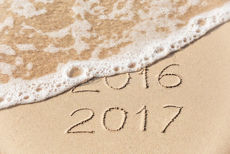de inschrijving van 2017 van 2016 die in het natte gele strandzand wordt geschreven die zijn stock afbeelding de inschrijving van 2017 van 2016 die in het natte gele strandzand wordt geschreven die zijn stock afbeelding
