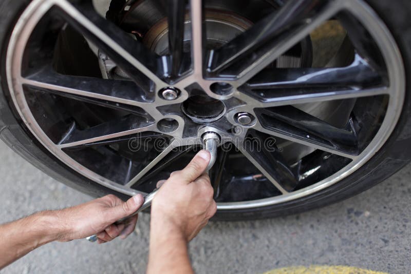 It is car wheel installation on the road. It is car wheel installation on the road