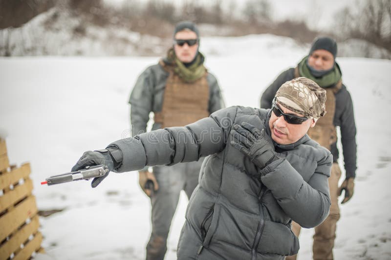 De instructeur toont het tactische kanon van het actiegevecht schietend aan aan zijn studenten stock foto De instructeur toont het tactische kanon van het actiegevecht schietend aan aan zijn studenten stock foto