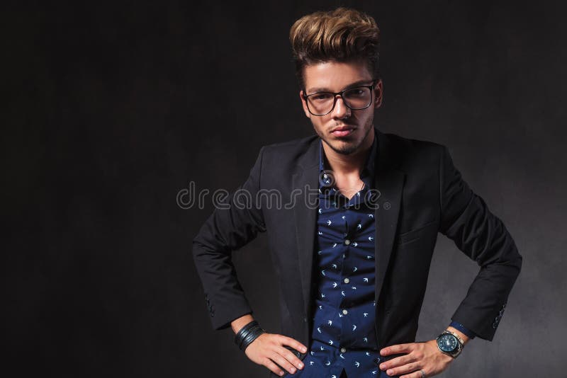De intelligente knappe mens die glazen dragen stelt in donkere studio met royalty-vrije stock fotografie De intelligente knappe mens die glazen dragen stelt in donkere studio met royalty-vrije stock fotografie