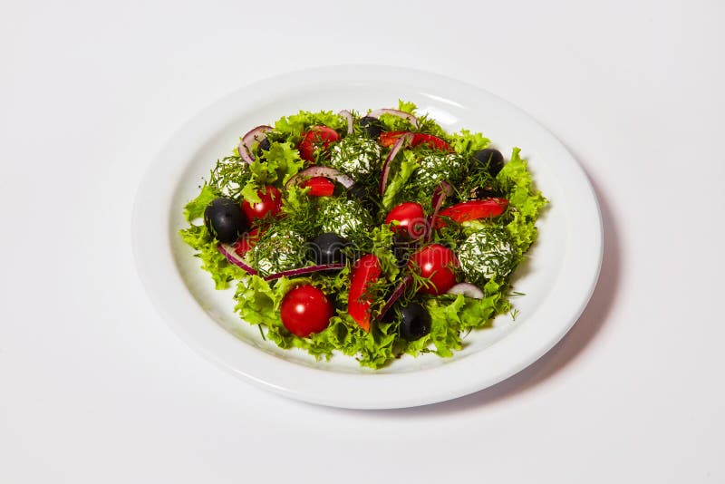 De Italiaanse salade van kaasballen met tomaten en verse groenten op de plaat royalty-vrije stock foto De Italiaanse salade van kaasballen met tomaten en verse groenten op de plaat royalty-vrije stock foto