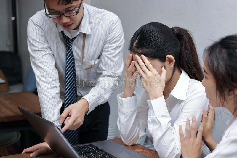 De jeunes femmes asiatiques déprimées soucieuses d'affaires sont blâmées avec le patron dans le lieu de travail images stock De jeunes femmes asiatiques déprimées soucieuses d'affaires sont blâmées avec le patron dans le lieu de travail images stock