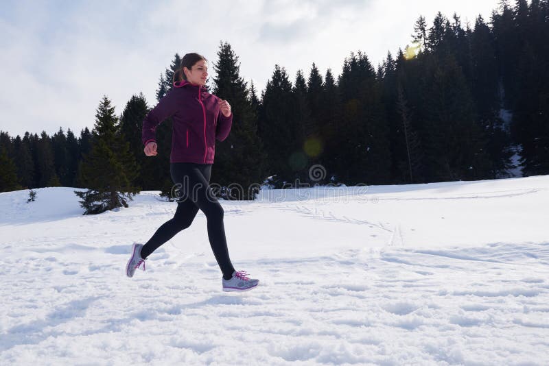 De jogging van de Yougnvrouw openlucht op sneeuw in bos stock afbeelding De jogging van de Yougnvrouw openlucht op sneeuw in bos stock afbeelding