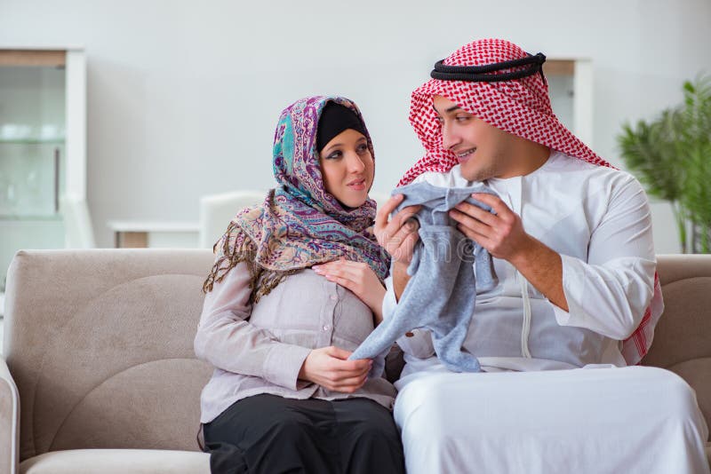 De jonge Arabische moslimfamilie met zwangere vrouw die baby verwachten stock foto De jonge Arabische moslimfamilie met zwangere vrouw die baby verwachten stock foto