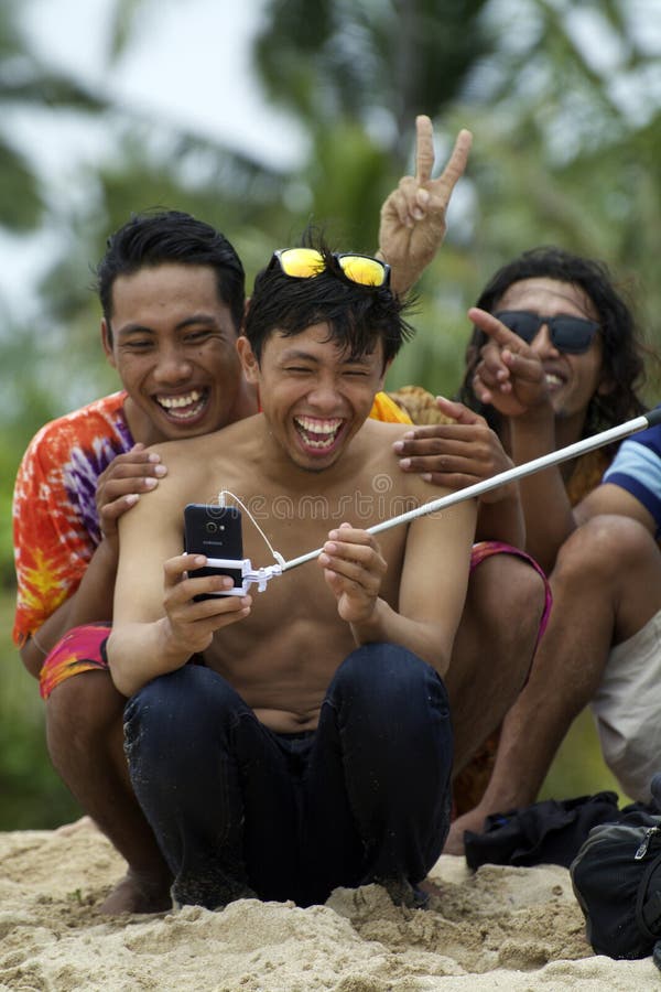 De jonge Aziatische mens die zonnebril dragen neemt selfie en lach met vrienden stock afbeelding De jonge Aziatische mens die zonnebril dragen neemt selfie en lach met vrienden stock afbeelding