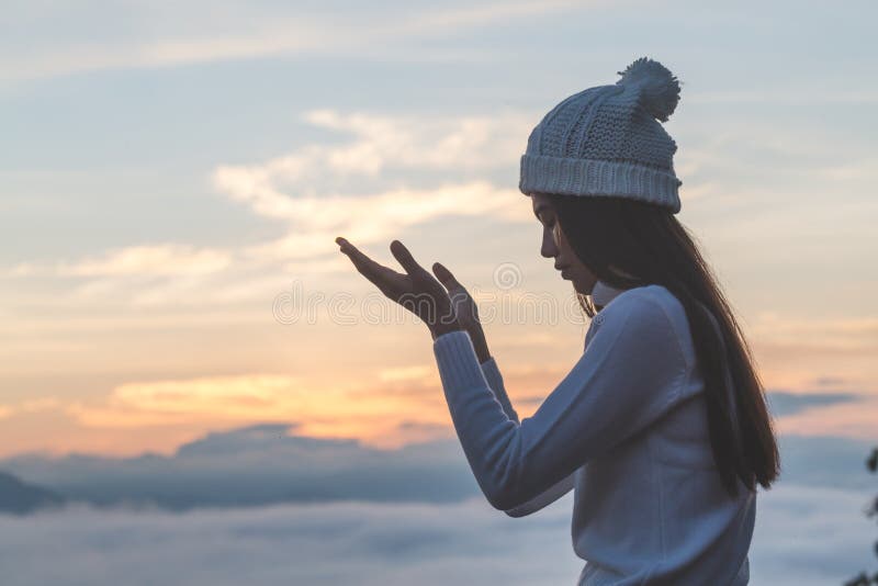 De jonge christelijke vrouw overhandigt open palm omhoog aanbidt en biddend aan god bij zonsopgang, Christian Religion-conceptena