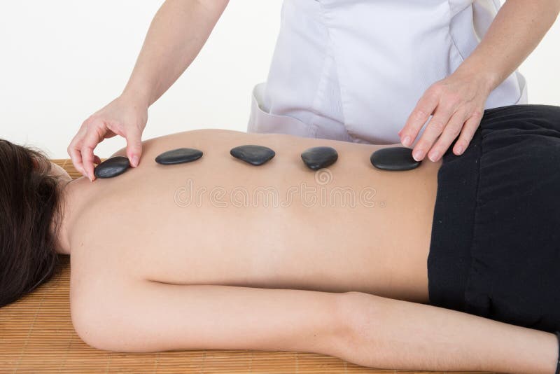 De jonge en gezonde vrouw in kuuroordsalon heeft heet de gezondheidsconcept van de steenmassage royalty-vrije stock foto De jonge en gezonde vrouw in kuuroordsalon heeft heet de gezondheidsconcept van de steenmassage royalty-vrije stock foto