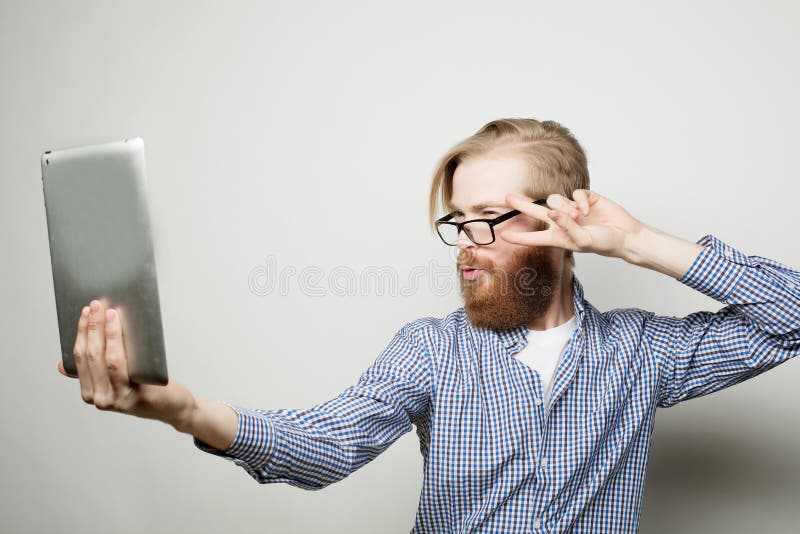 De jonge gebaarde tablet van de mensenholding royalty-vrije stock foto