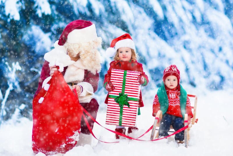 De jonge geitjes en de Kerstman met Kerstmis stellen voor royalty-vrije stock foto's De jonge geitjes en de Kerstman met Kerstmis stellen voor royalty-vrije stock foto's