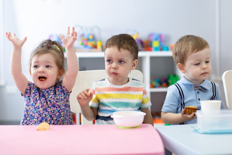 De jonge geitjes hebben een lunch in opvangcentrum Kinderen die in kleuterschool eten royalty-vrije stock foto's De jonge geitjes hebben een lunch in opvangcentrum Kinderen die in kleuterschool eten royalty-vrije stock foto's