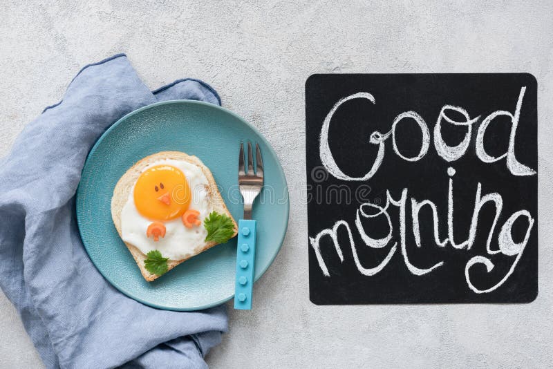 De jonge geitjes van het ontbijtvoedsel Grappige toost met ei en goedemorgentekst stock foto De jonge geitjes van het ontbijtvoedsel Grappige toost met ei en goedemorgentekst stock foto