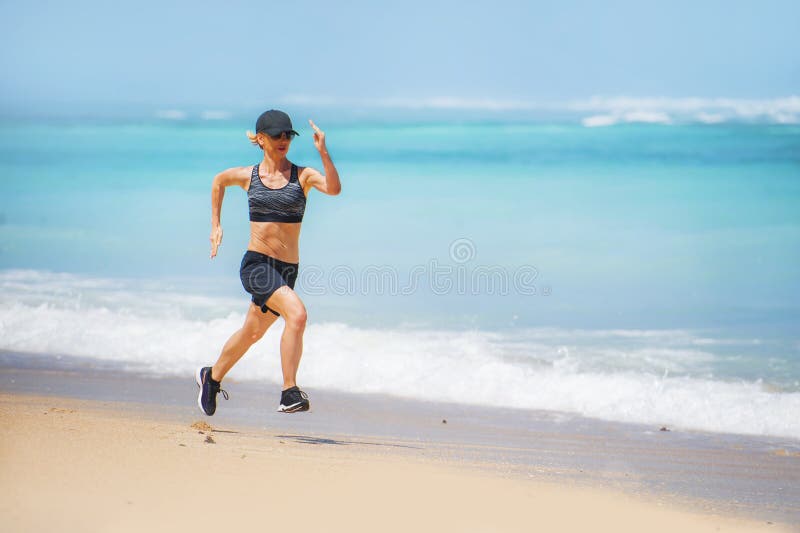 De jonge gelukkige en aantrekkelijke vrouw die van de sportagent lopende training doen die bij het tropische paradijsstrand gesch royalty-vrije stock afbeelding De jonge gelukkige en aantrekkelijke vrouw die van de sportagent lopende training doen die bij het tropische paradijsstrand gesch royalty-vrije stock afbeelding
