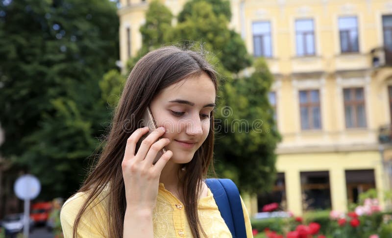 De jonge gelukkige Kaukasische vrouw roept met een mobiele telefoon in de stad stock foto De jonge gelukkige Kaukasische vrouw roept met een mobiele telefoon in de stad stock foto