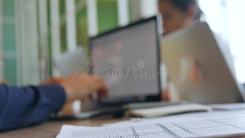 De jonge Glazen van Programmeursman puts on en beginnen aan Computerlaptop te werken Glazen die op Lijst in Bureau leggen 4K