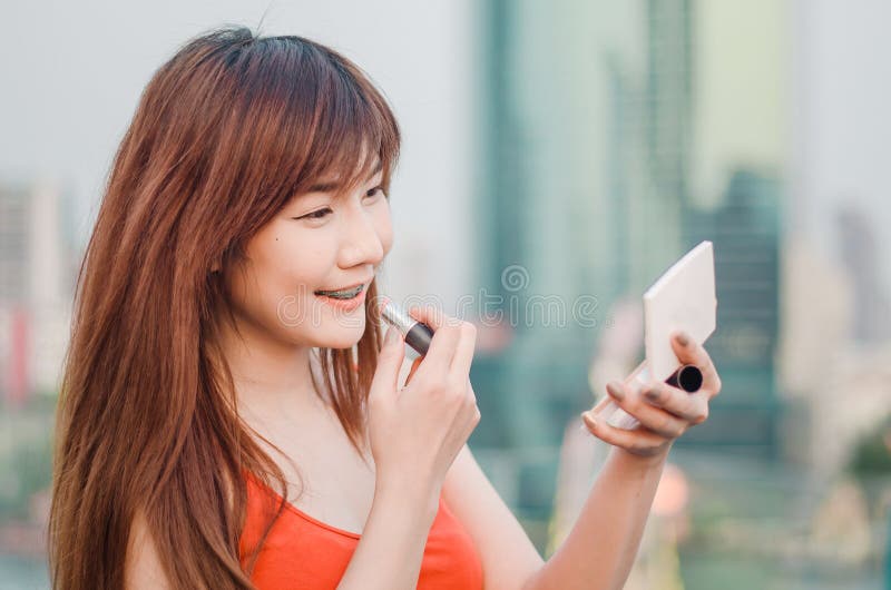 De jonge het glimlachen lippen van de bedrijfsvrouwentekening met lippenstift die zich in openlucht over stad bevinden royalty-vrije stock foto's De jonge het glimlachen lippen van de bedrijfsvrouwentekening met lippenstift die zich in openlucht over stad bevinden royalty-vrije stock foto's