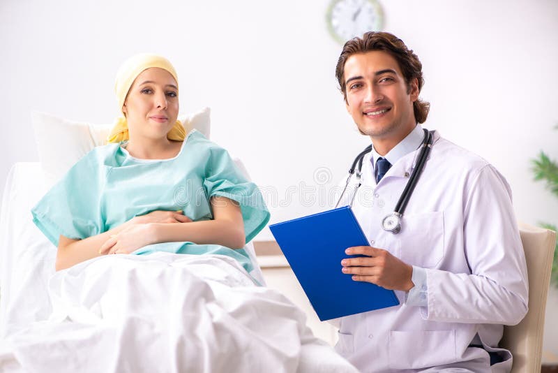De jonge knappe arts die vrouwelijke oncologiepatiënt bezoeken royalty-vrije stock afbeeldingen De jonge knappe arts die vrouwelijke oncologiepatiënt bezoeken royalty-vrije stock afbeeldingen