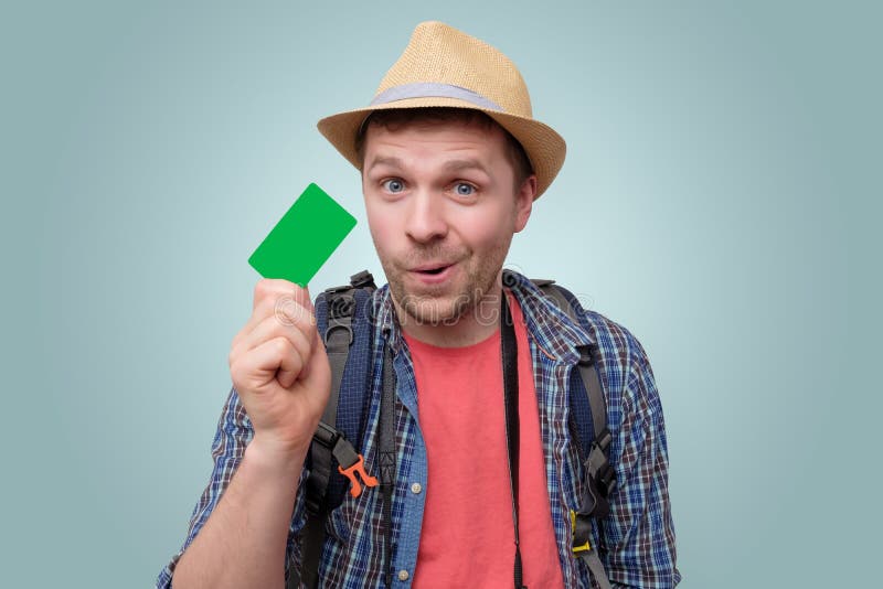 De jonge knappe toeristenmens houdt groene creditcard stock afbeelding De jonge knappe toeristenmens houdt groene creditcard stock afbeelding