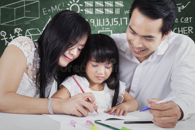 De jonge leraar onderwijst een kind om te schrijven stock afbeelding De jonge leraar onderwijst een kind om te schrijven stock afbeelding