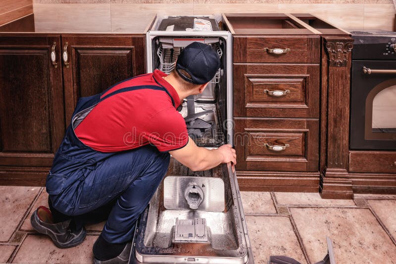 De jonge Mannelijke Keuken van Technicusrepairing dishwasher in royalty-vrije stock afbeeldingen De jonge Mannelijke Keuken van Technicusrepairing dishwasher in royalty-vrije stock afbeeldingen