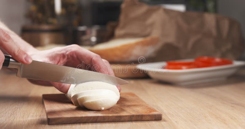 De jonge mens overhandigt snijdende mozarellakaas stock afbeelding De jonge mens overhandigt snijdende mozarellakaas stock afbeelding