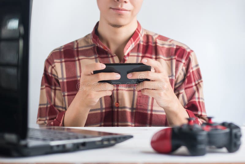 De jonge Mensen dragen het rode Scott-van de de Handholding van het patroonoverhemd spel van het smartphonespel op smartphone stock foto's De jonge Mensen dragen het rode Scott-van de de Handholding van het patroonoverhemd spel van het smartphonespel op smartphone stock foto's