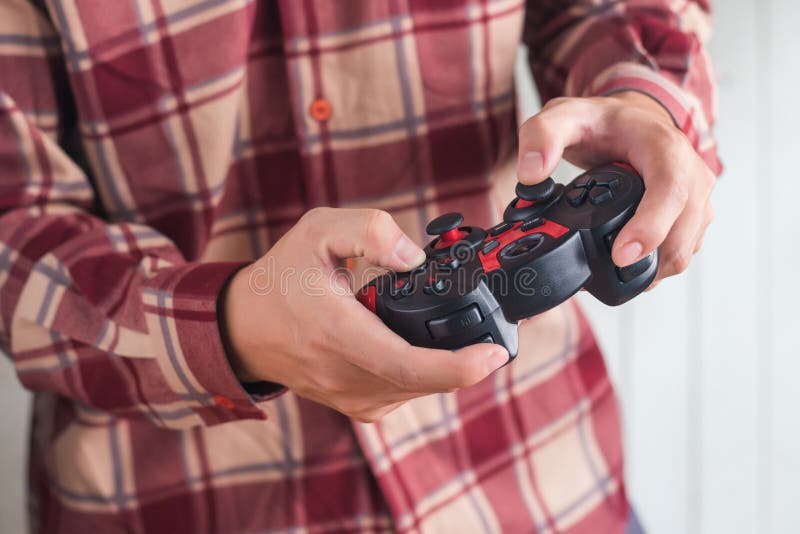 De jonge mensen dragen rood Scott-van de de Handholding van het patroonoverhemd de Bedieningshendel gamepad speelspel stock foto's De jonge mensen dragen rood Scott-van de de Handholding van het patroonoverhemd de Bedieningshendel gamepad speelspel stock foto's