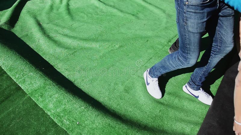 De jonge mensen maken reusachtig groen tapijt op Bouw stadium voor gebeurtenis op straat Arbeiders