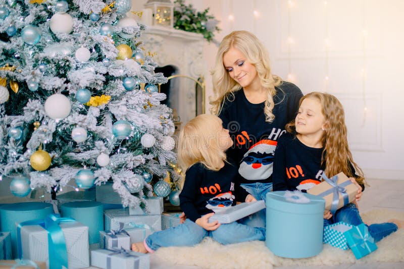 De jonge moeder giften aan geeft haar kleine dochters royalty-vrije stock afbeeldingen De jonge moeder giften aan geeft haar kleine dochters royalty-vrije stock afbeeldingen