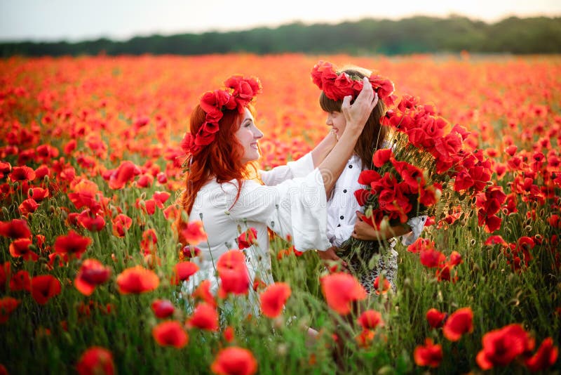 De jonge moeder zet kroon van papaverbloemen op het hoofd van haar dochter, omhoog sluit royalty-vrije stock foto's De jonge moeder zet kroon van papaverbloemen op het hoofd van haar dochter, omhoog sluit royalty-vrije stock foto's