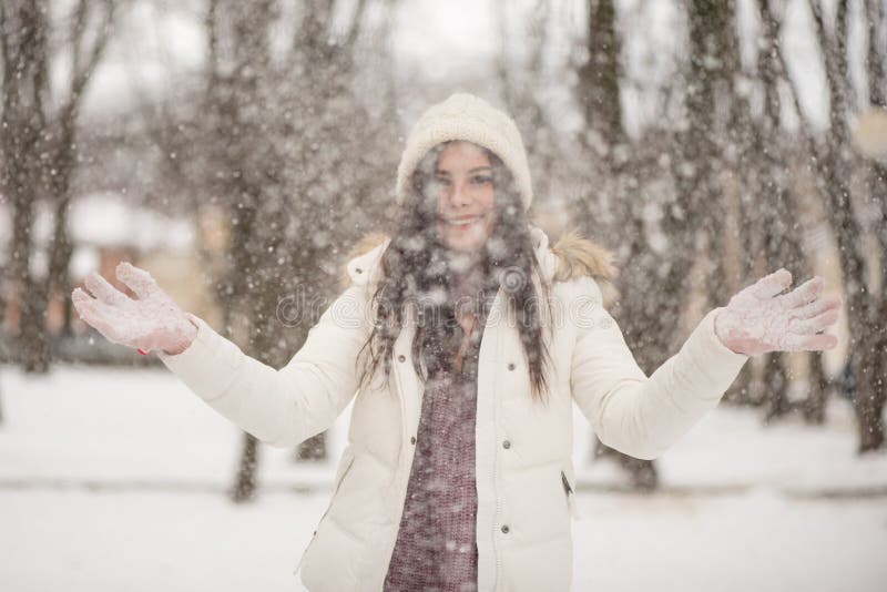 De jonge mooie vrouw geniet van de sneeuw die het verspreiden in de lucht, de positieve emoties, de vreugde en het geluk de winte royalty-vrije stock foto's De jonge mooie vrouw geniet van de sneeuw die het verspreiden in de lucht, de positieve emoties, de vreugde en het geluk de winte royalty-vrije stock foto's