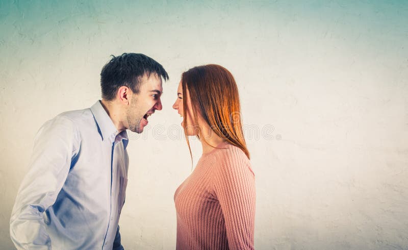 De jonge paarman en de vrouw die op de witte achtergrond gillen stock afbeelding De jonge paarman en de vrouw die op de witte achtergrond gillen stock afbeelding