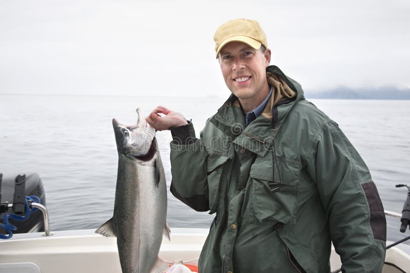 De jonge visser in Alaska steunt een aardige zilveren zalm