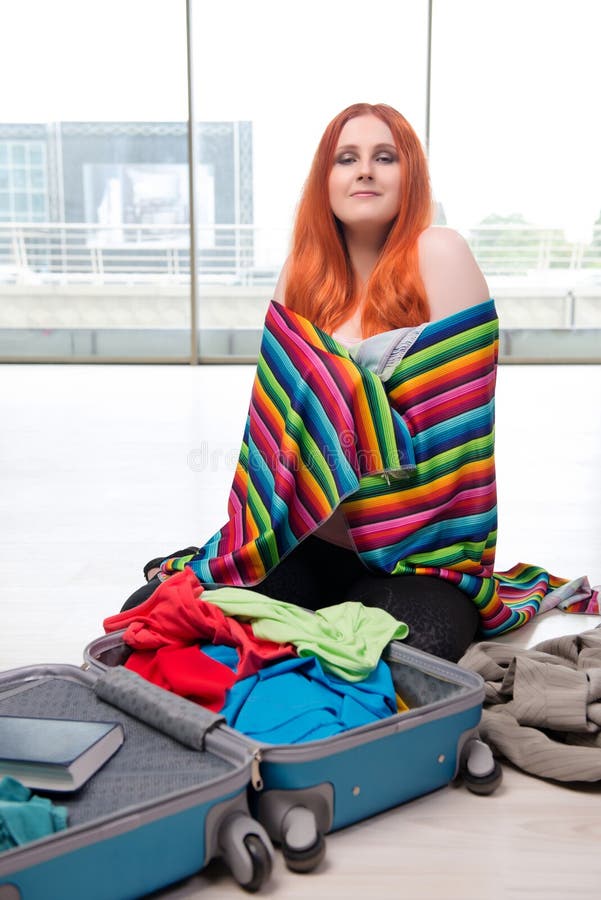 De jonge vrouwenverpakking voor reisvakantie stock afbeelding De jonge vrouwenverpakking voor reisvakantie stock afbeelding