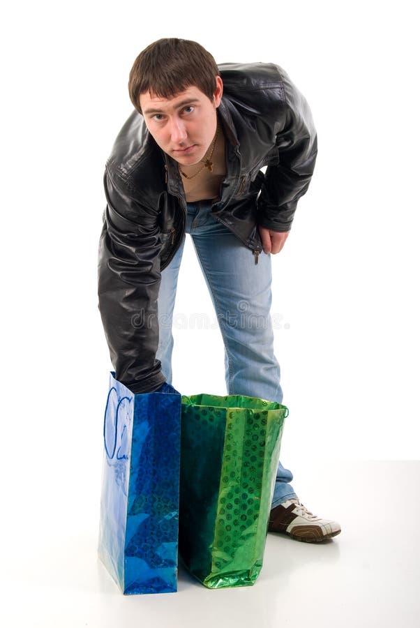 Young Guy In Black Leather Jacket And Shopping Bags. Studio Shoot Over White Background. Young Guy In Black Leather Jacket And Shopping Bags. Studio Shoot Over White Background.